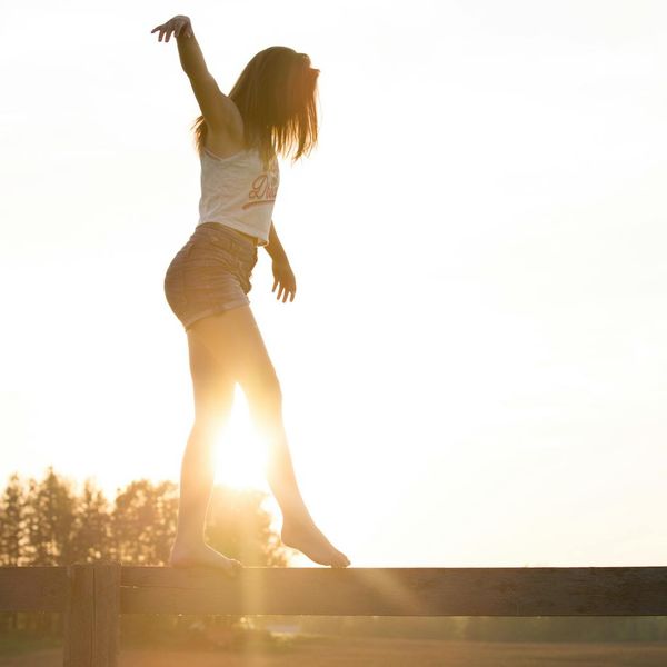Person feeling energetic and stretching outdoors at sunrise.